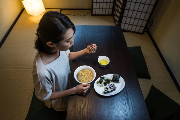 アジアの女性が東京で伝統的な日本のアパートで食べる — ストック写真