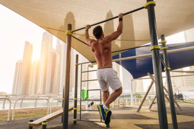 Genç atletik eğitim açık havada - Genç Yetişkin bir fitness egzersiz yapıyor adam