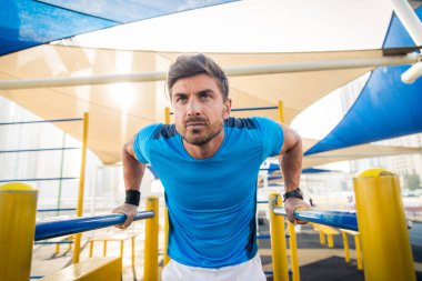 Genç atletik eğitim açık havada - Genç Yetişkin bir fitness egzersiz yapıyor adam