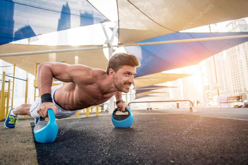 Young athletic man training outdoors - Young adult doing a fitness workout