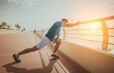 Genç atletik eğitim açık havada - Genç Yetişkin bir fitness egzersiz yapıyor adam