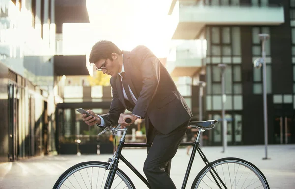 Handsome young business man with his modern bicycle.