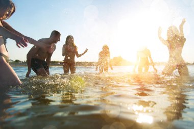 Denizde - mutlu gençler yaz tatilde plajda eğlenmek arkadaş grubu