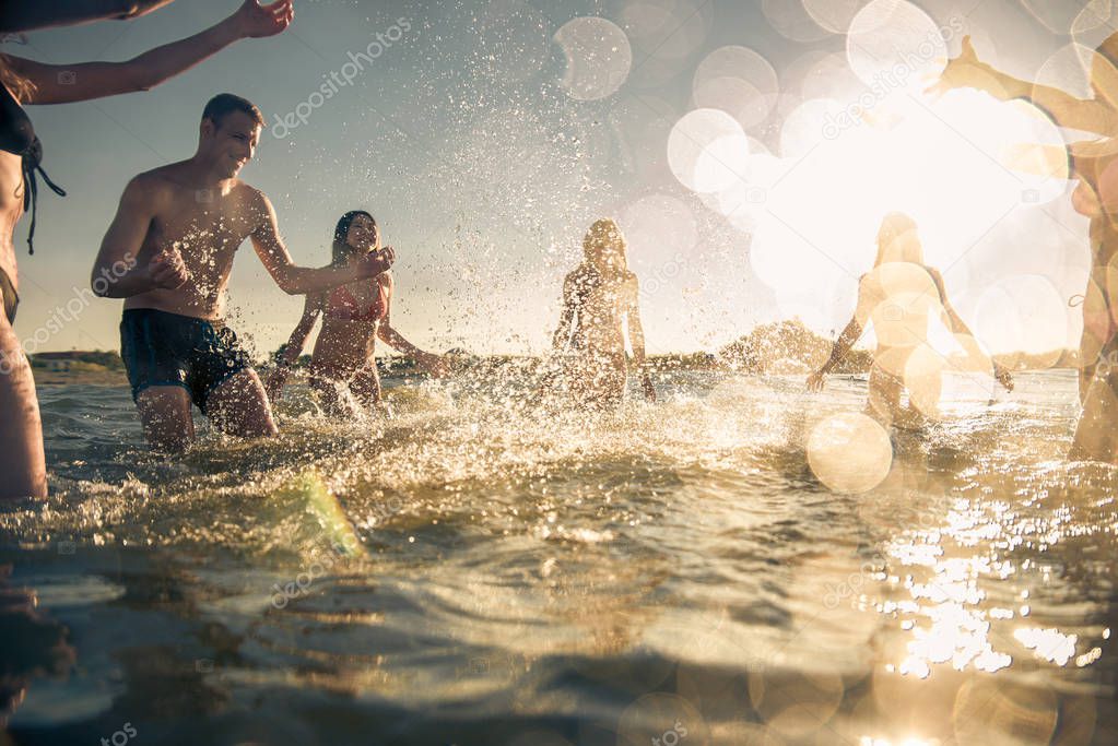 Group of friends having fun at the sea - Happy young people on a summer vacation at the beach