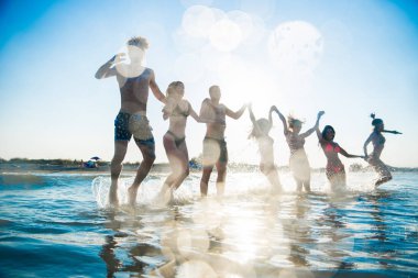 Denizde - mutlu gençler yaz tatilde plajda eğlenmek arkadaş grubu
