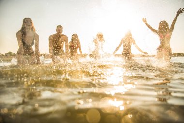 Denizde - mutlu gençler yaz tatilde plajda eğlenmek arkadaş grubu