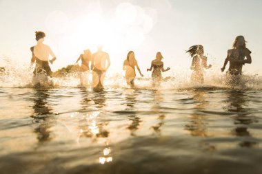Denizde - mutlu gençler yaz tatilde plajda eğlenmek arkadaş grubu