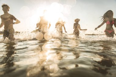 Denizde - mutlu gençler yaz tatilde plajda eğlenmek arkadaş grubu