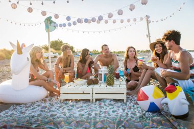 Sahilde - mutlu gençler yaz tatilde plajda piknik arkadaş grubu