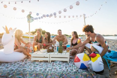Sahilde - mutlu gençler yaz tatilde plajda piknik arkadaş grubu