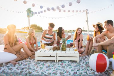 Sahilde - mutlu gençler yaz tatilde plajda piknik arkadaş grubu
