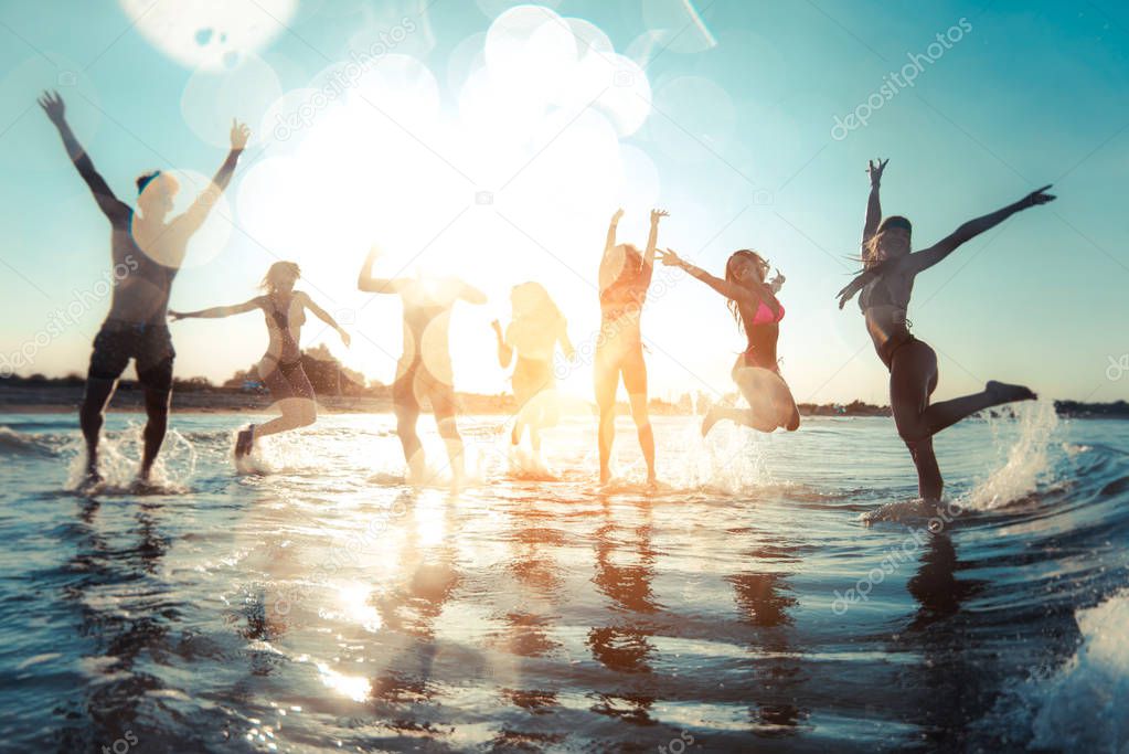 Group of friends having fun at the sea - Happy young people on a summer vacation at the beach