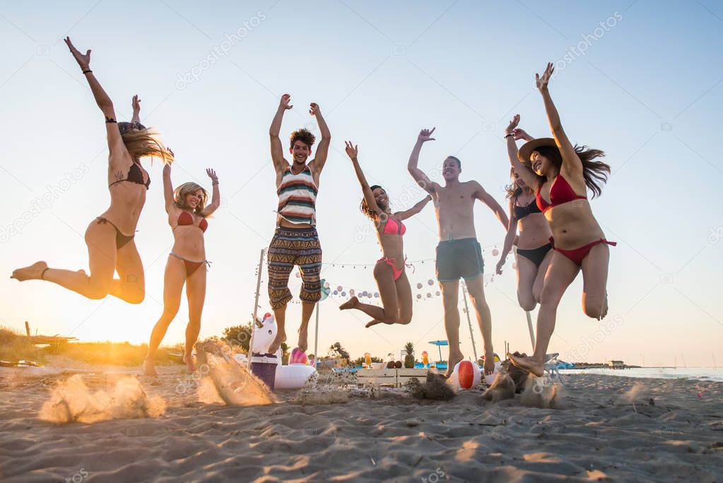 Happy group of friends celebrating and having fun on the beach - Young people on summer holiday