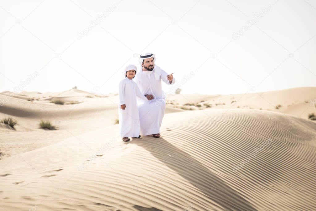 Happy family playing in the desert of Dubai -  Playful father and his son having fun outdoors