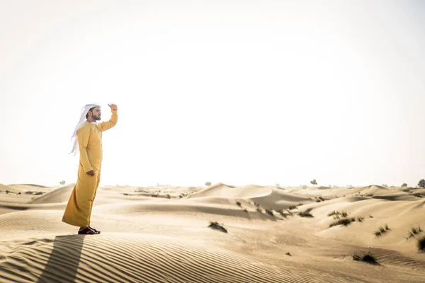 Handsome arabian man with traditional dress in the desert of Dubai