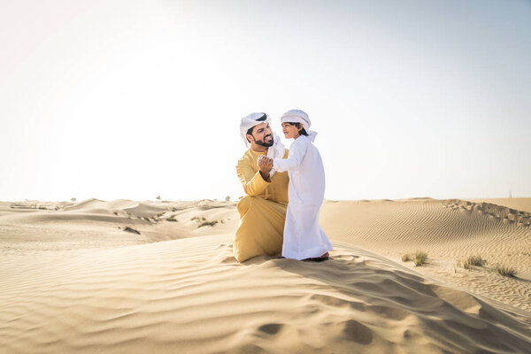 Happy family playing in the desert of Dubai -  Playful father and his son having fun outdoors