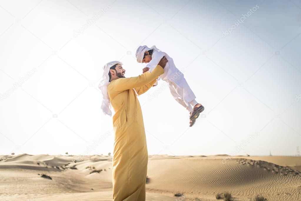 Happy family playing in the desert of Dubai -  Playful father and his son having fun outdoors