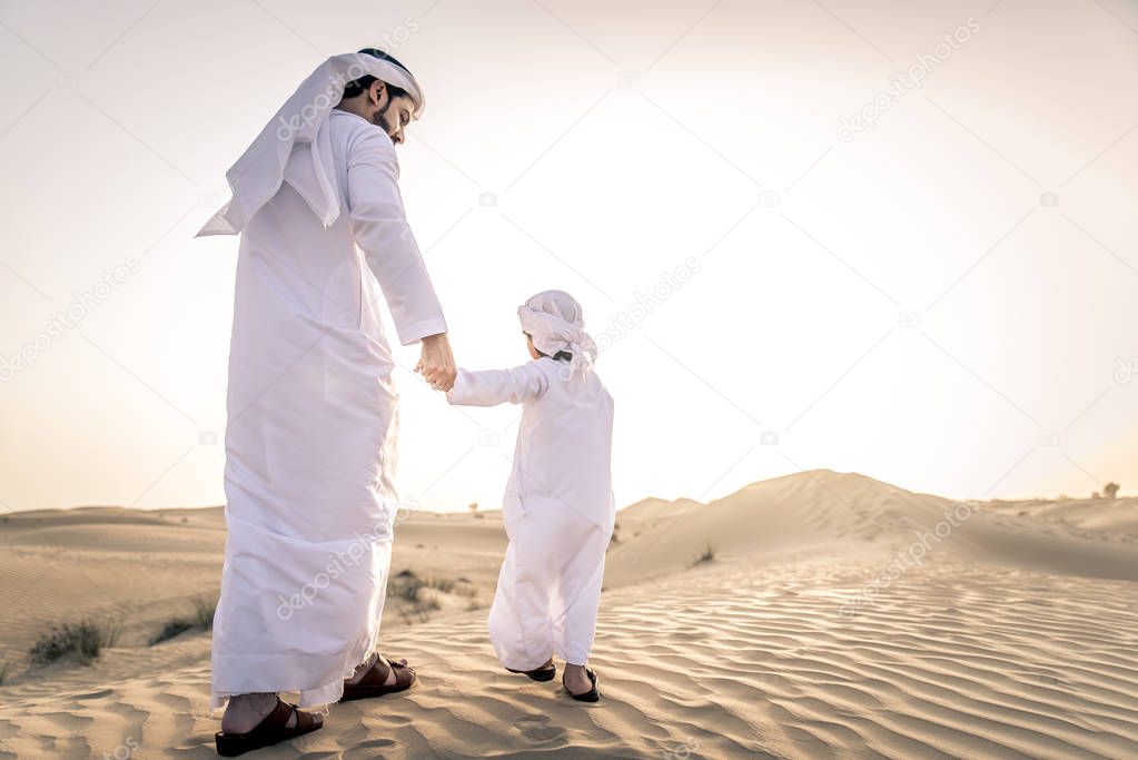 Happy family playing in the desert of Dubai -  Playful father and his son having fun outdoors