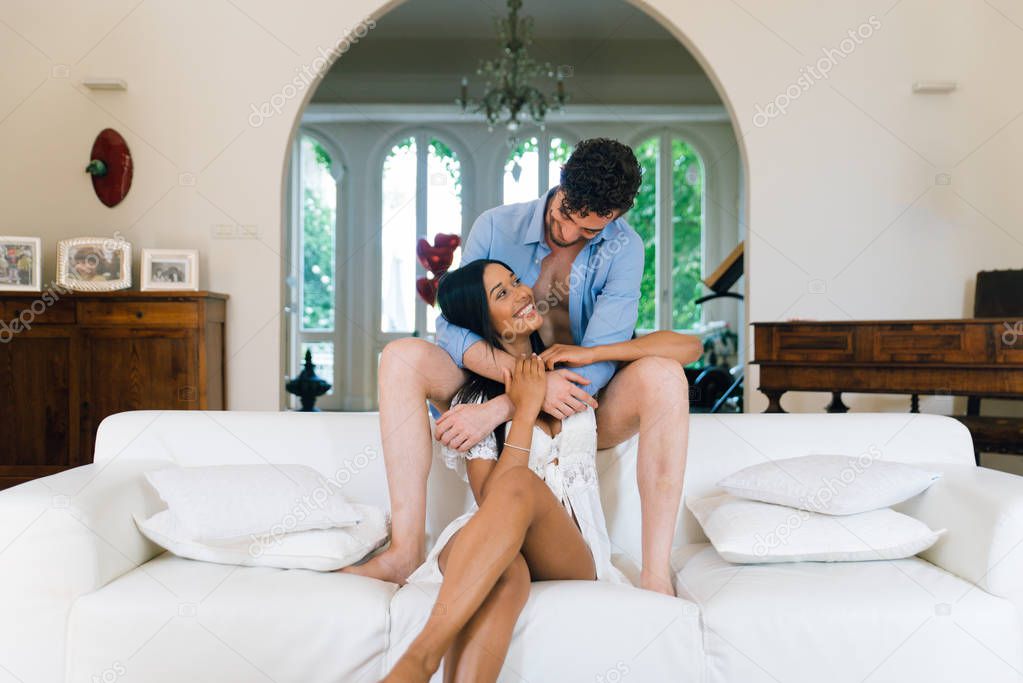 Young happy couple relaxing and having fun on the sofa at home