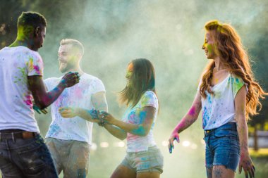 Holi ile oynarken mutlu arkadaş grubu bir parkta - Genç Yetişkin eğlenceli, eğlenceli ve genç nesil hakkındaki kavramları bir holi Festivali, eğleniyor renkler.