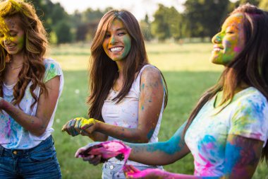 Holi ile oynarken mutlu arkadaş grubu bir parkta - Genç Yetişkin eğlenceli, eğlenceli ve genç nesil hakkındaki kavramları bir holi Festivali, eğleniyor renkler.