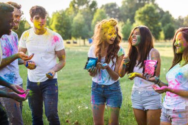 Holi ile oynarken mutlu arkadaş grubu bir parkta - Genç Yetişkin eğlenceli, eğlenceli ve genç nesil hakkındaki kavramları bir holi Festivali, eğleniyor renkler.