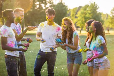 Holi ile oynarken mutlu arkadaş grubu bir parkta - Genç Yetişkin eğlenceli, eğlenceli ve genç nesil hakkındaki kavramları bir holi Festivali, eğleniyor renkler.