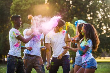 Holi ile oynarken mutlu arkadaş grubu bir parkta - Genç Yetişkin eğlenceli, eğlenceli ve genç nesil hakkındaki kavramları bir holi Festivali, eğleniyor renkler.