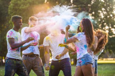 Holi ile oynarken mutlu arkadaş grubu bir parkta - Genç Yetişkin eğlenceli, eğlenceli ve genç nesil hakkındaki kavramları bir holi Festivali, eğleniyor renkler.