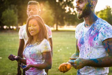 Holi ile oynarken mutlu arkadaş grubu bir parkta - Genç Yetişkin eğlenceli, eğlenceli ve genç nesil hakkındaki kavramları bir holi Festivali, eğleniyor renkler.