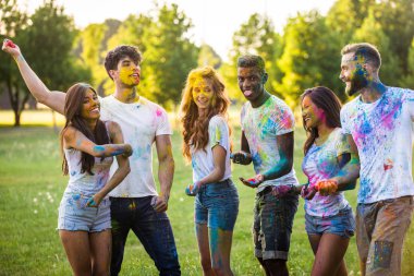 Holi ile oynarken mutlu arkadaş grubu bir parkta - Genç Yetişkin eğlenceli, eğlenceli ve genç nesil hakkındaki kavramları bir holi Festivali, eğleniyor renkler.