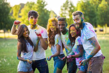 Holi ile oynarken mutlu arkadaş grubu bir parkta - Genç Yetişkin eğlenceli, eğlenceli ve genç nesil hakkındaki kavramları bir holi Festivali, eğleniyor renkler.