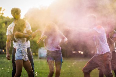 Holi ile oynarken mutlu arkadaş grubu bir parkta - Genç Yetişkin eğlenceli, eğlenceli ve genç nesil hakkındaki kavramları bir holi Festivali, eğleniyor renkler.