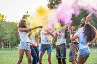 Holi ile oynarken mutlu arkadaş grubu bir parkta - Genç Yetişkin eğlenceli, eğlenceli ve genç nesil hakkındaki kavramları bir holi Festivali, eğleniyor renkler.
