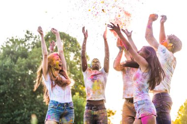 Holi ile oynarken mutlu arkadaş grubu bir parkta - Genç Yetişkin eğlenceli, eğlenceli ve genç nesil hakkındaki kavramları bir holi Festivali, eğleniyor renkler.