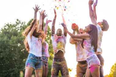 Holi ile oynarken mutlu arkadaş grubu bir parkta - Genç Yetişkin eğlenceli, eğlenceli ve genç nesil hakkındaki kavramları bir holi Festivali, eğleniyor renkler.