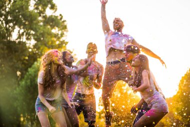 Holi ile oynarken mutlu arkadaş grubu bir parkta - Genç Yetişkin eğlenceli, eğlenceli ve genç nesil hakkındaki kavramları bir holi Festivali, eğleniyor renkler.