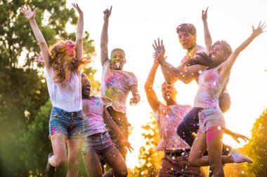 Holi ile oynarken mutlu arkadaş grubu bir parkta - Genç Yetişkin eğlenceli, eğlenceli ve genç nesil hakkındaki kavramları bir holi Festivali, eğleniyor renkler.