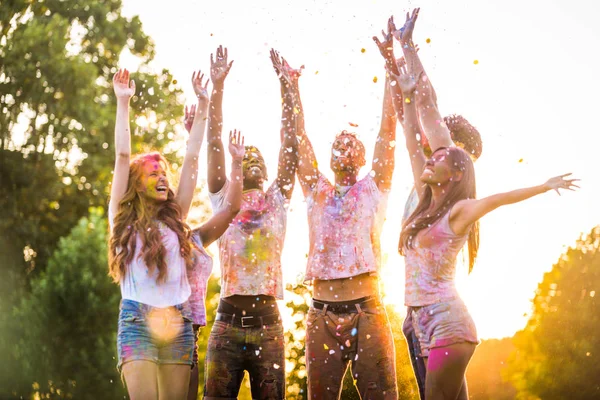 stock image Group of happy friends playing with holi colors in a park - Young adults having fun at a holi festival, concepts about fun, fun and young generation