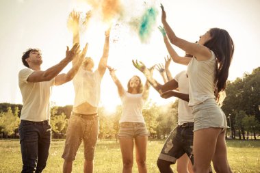 Holi ile oynarken mutlu arkadaş grubu bir parkta - Genç Yetişkin eğlenceli, eğlenceli ve genç nesil hakkındaki kavramları bir holi Festivali, eğleniyor renkler.