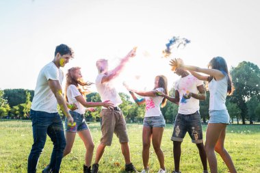 Holi ile oynarken mutlu arkadaş grubu bir parkta - Genç Yetişkin eğlenceli, eğlenceli ve genç nesil hakkındaki kavramları bir holi Festivali, eğleniyor renkler.
