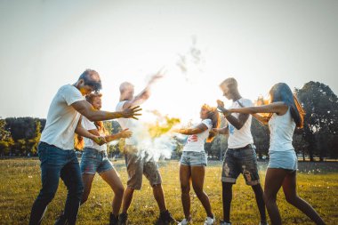 Holi ile oynarken mutlu arkadaş grubu bir parkta - Genç Yetişkin eğlenceli, eğlenceli ve genç nesil hakkındaki kavramları bir holi Festivali, eğleniyor renkler.