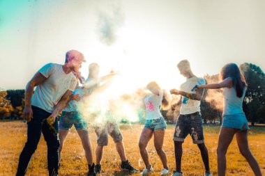Holi ile oynarken mutlu arkadaş grubu bir parkta - Genç Yetişkin eğlenceli, eğlenceli ve genç nesil hakkındaki kavramları bir holi Festivali, eğleniyor renkler.