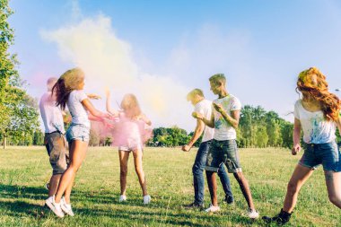 Holi ile oynarken mutlu arkadaş grubu bir parkta - Genç Yetişkin eğlenceli, eğlenceli ve genç nesil hakkındaki kavramları bir holi Festivali, eğleniyor renkler.