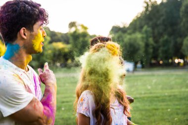 Holi ile oynarken mutlu arkadaş grubu bir parkta - Genç Yetişkin eğlenceli, eğlenceli ve genç nesil hakkındaki kavramları bir holi Festivali, eğleniyor renkler.