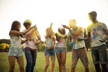 Holi ile oynarken mutlu arkadaş grubu bir parkta - Genç Yetişkin eğlenceli, eğlenceli ve genç nesil hakkındaki kavramları bir holi Festivali, eğleniyor renkler.