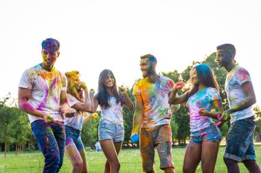 Holi ile oynarken mutlu arkadaş grubu bir parkta - Genç Yetişkin eğlenceli, eğlenceli ve genç nesil hakkındaki kavramları bir holi Festivali, eğleniyor renkler.