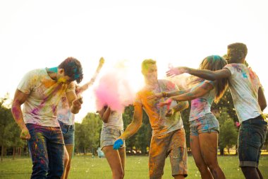 Holi ile oynarken mutlu arkadaş grubu bir parkta - Genç Yetişkin eğlenceli, eğlenceli ve genç nesil hakkındaki kavramları bir holi Festivali, eğleniyor renkler.