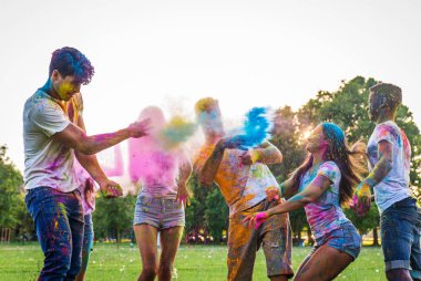 Holi ile oynarken mutlu arkadaş grubu bir parkta - Genç Yetişkin eğlenceli, eğlenceli ve genç nesil hakkındaki kavramları bir holi Festivali, eğleniyor renkler.