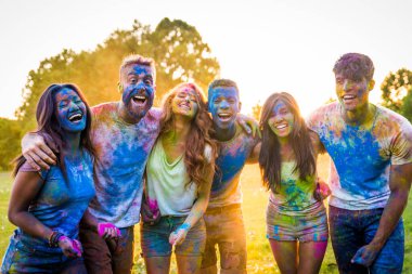 Holi ile oynarken mutlu arkadaş grubu bir parkta - Genç Yetişkin eğlenceli, eğlenceli ve genç nesil hakkındaki kavramları bir holi Festivali, eğleniyor renkler.